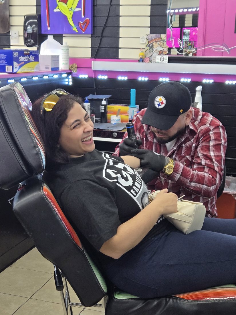 Nagham laughing in the tattoo chair