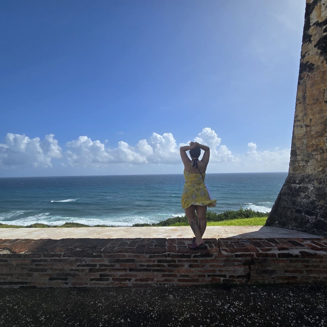 Nagham on the El Morro wall above the ocean